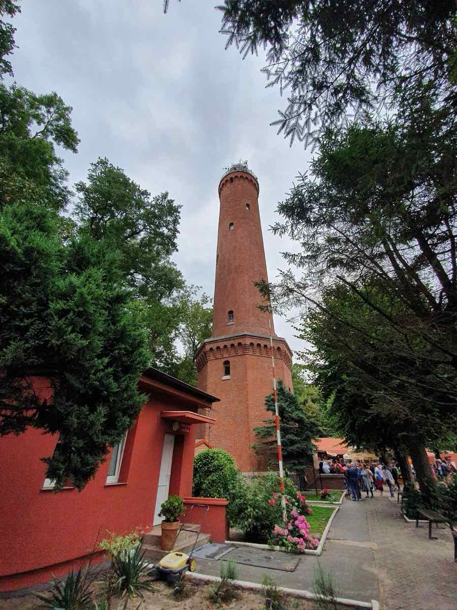 Ceglana latarnia morska w Gąskach wśród drzew
