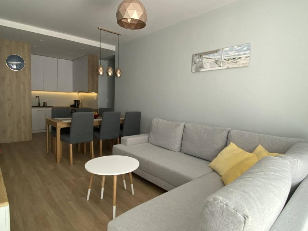 Salon z rozkładaną sofą, jadalnią i kuchnią w tle